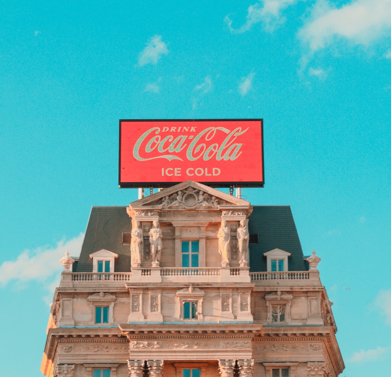 a large coca cola sign on top of a building